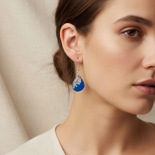 Woman wearing Azure Veil Australian handmade earrings in soft blue resin with silver shimmer by Katie Tilson Studios