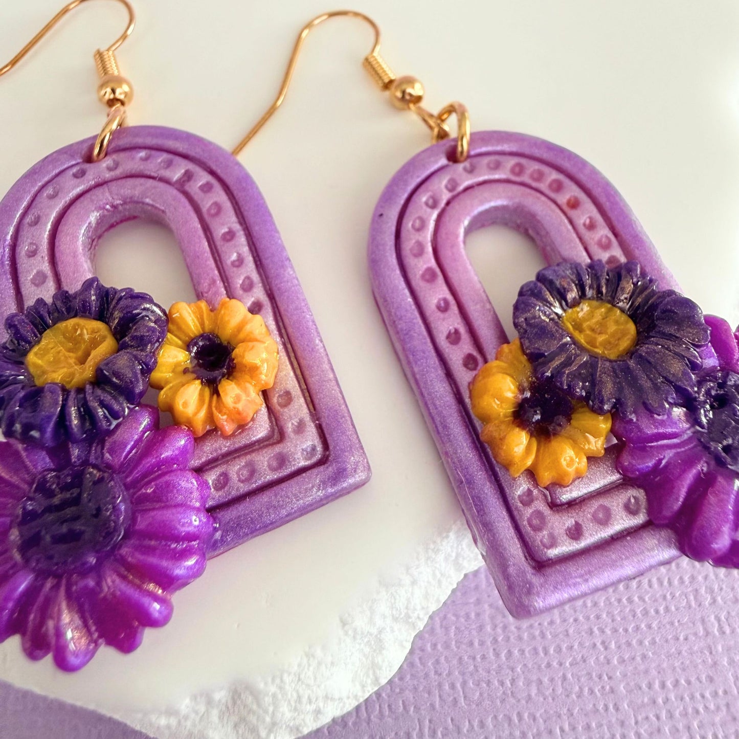 Australian handmade purple floral arch dangle earrings with gold hooks on a white background