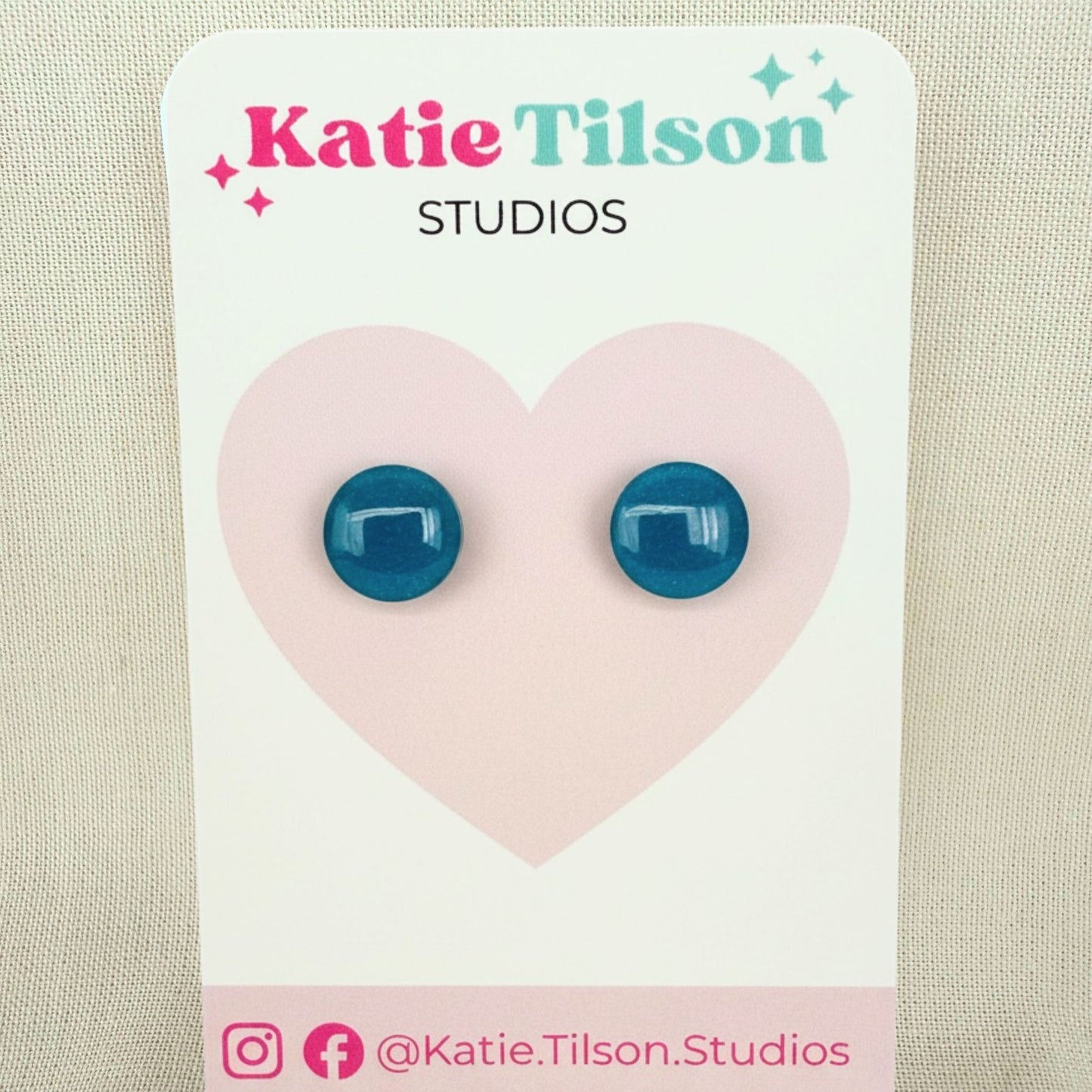 Teal circular stud earrings on a Katie Tilson Studios branded card against a beige background.