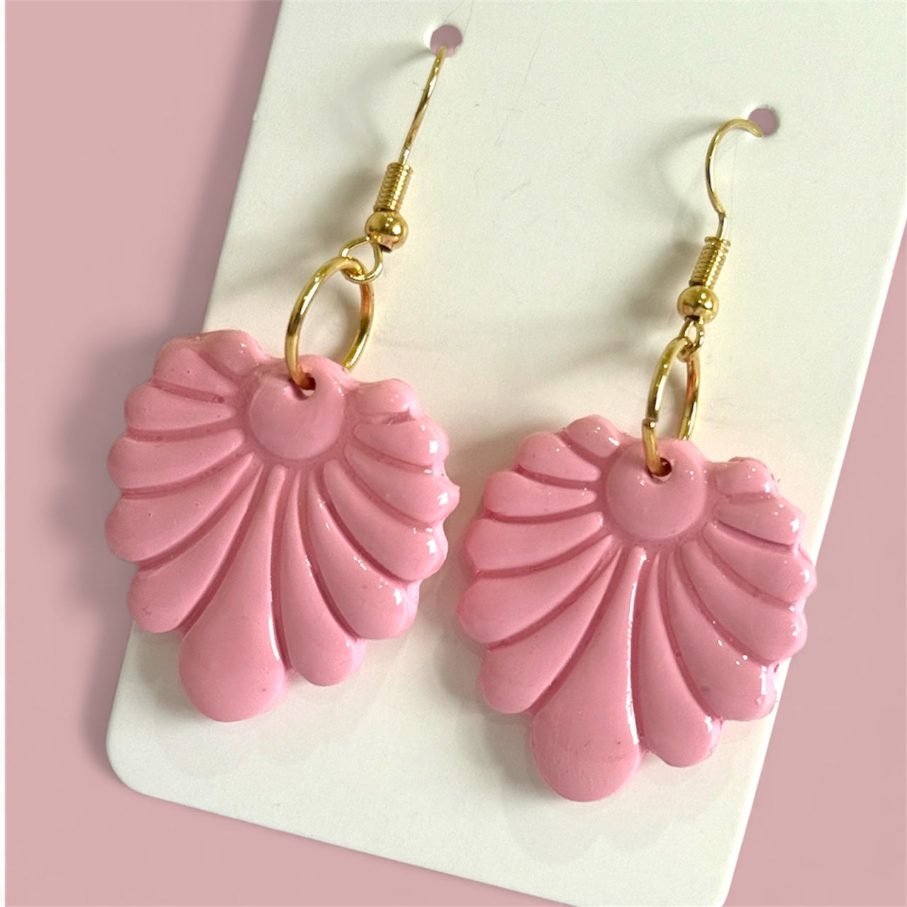 pink shell inspired polymer clay earrings on a soft pink background