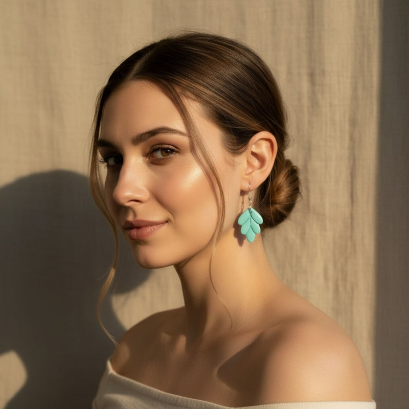 Woman wearing Aqua Leaf aqua colour leaf shaped handmade dangle earrings.