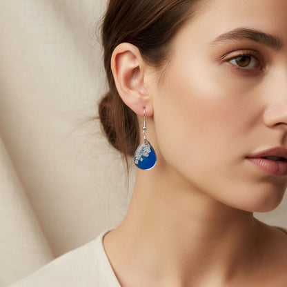 Woman wearing Azure Veil Australian handmade earrings in soft blue resin with silver shimmer by Katie Tilson Studios