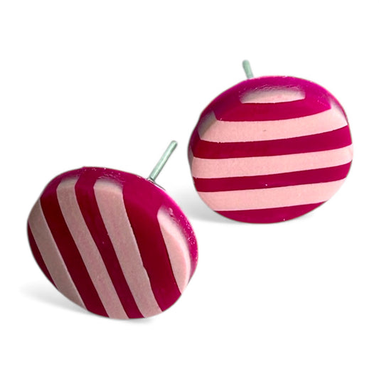 Pair of round stud earrings with dark pink and pastel pink striped design on a white background