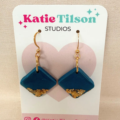 Bright Side Australian handmade teal dangle earrings in diamond shape with gold leaf detail on a branded earring card.