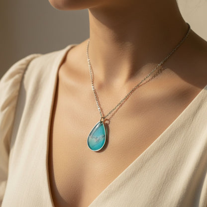 Woman wearing Coastal Glow Australian handmade necklace in coastal blue resin with soft shimmer by Katie Tilson Studios