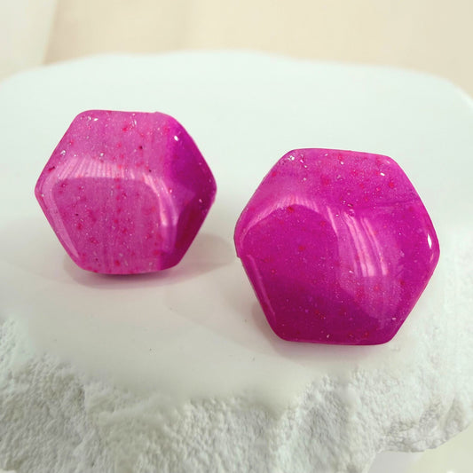 Australian handmade stud earrings in a pink and purple geometric design with silver flecks on a white background.