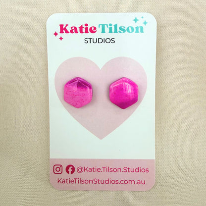 Pink and purple geometric stud earrings on a Katie Tilson Studios card with a beige background.