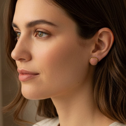Woman wearing Everyday Studs blush pink domed clay earrings with gold bezel.