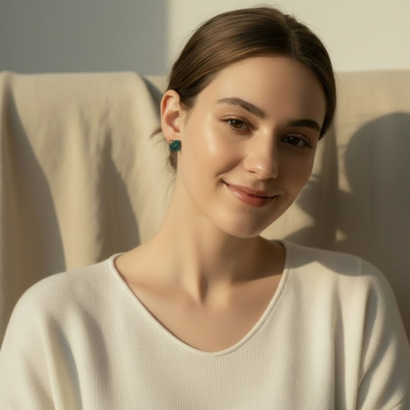 Woman wearing Gilded Tide Australian handmade resin stud earrings in teal and gold.