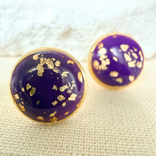 Close up of Good Vibes handmade stud earrings in violet colour with gold flecks and gold bezel.