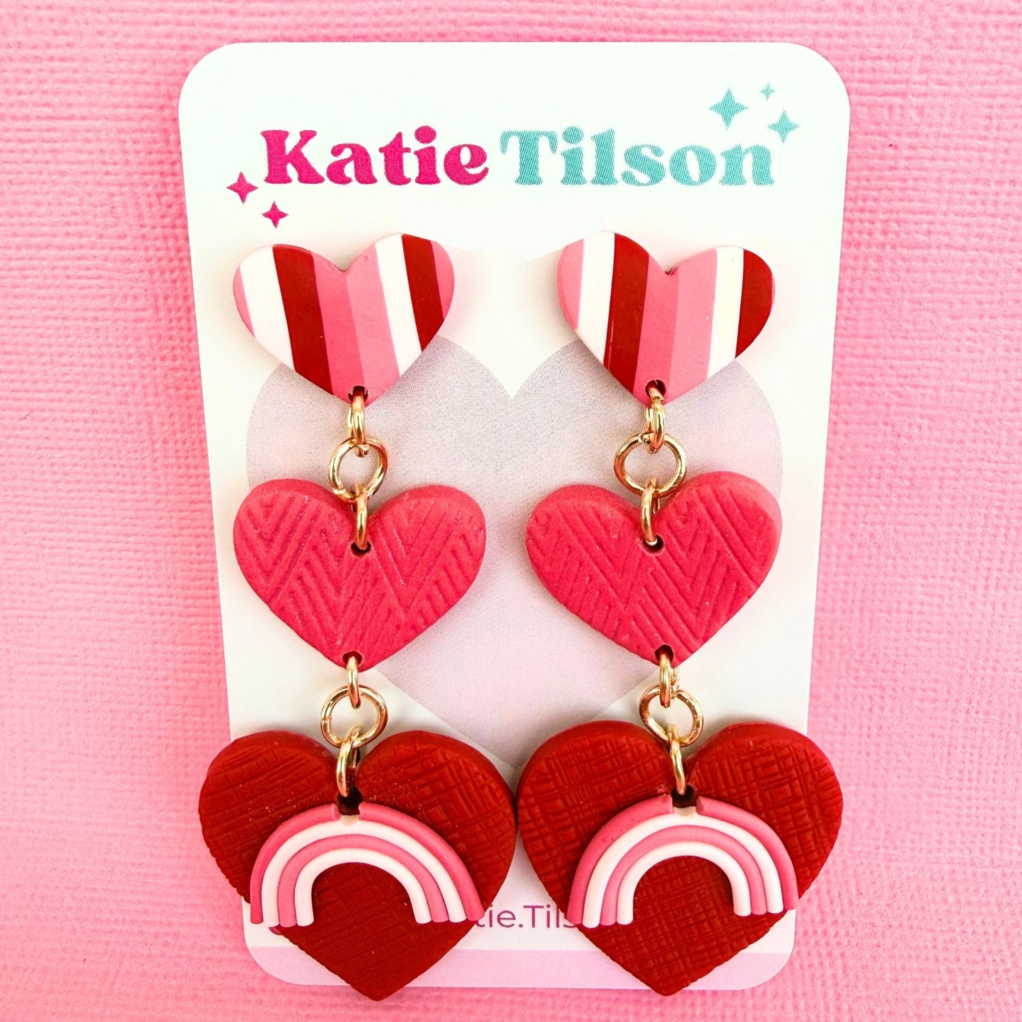 Australian handmade statement drop earrings in heart shaped design on a Katie Tilson Studios branded earring card against a pink background.