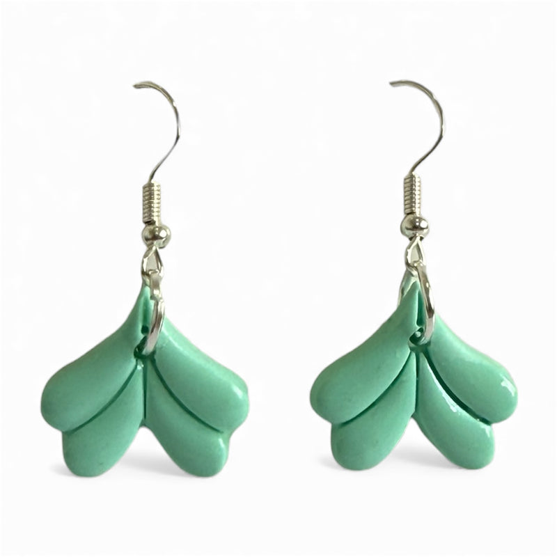 Mermaid-inspired polymer clay dangle earrings in mint green on a white background.