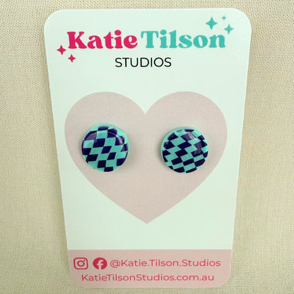 Pair of mint and violet check stud earrings on a Katie Tilson Studios earring card.