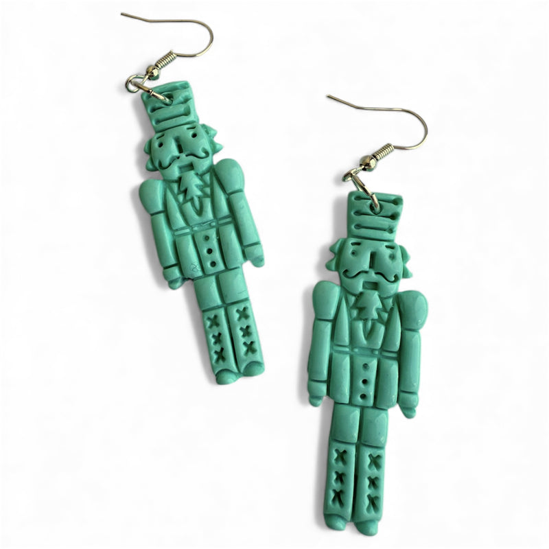 Festive mint green polymer clay Christmas Nutcracker dangle earrings.
