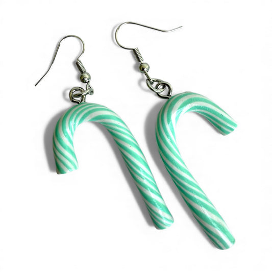 a pair of handmade green and white candy cane earrings with silver earring hooks on a white background