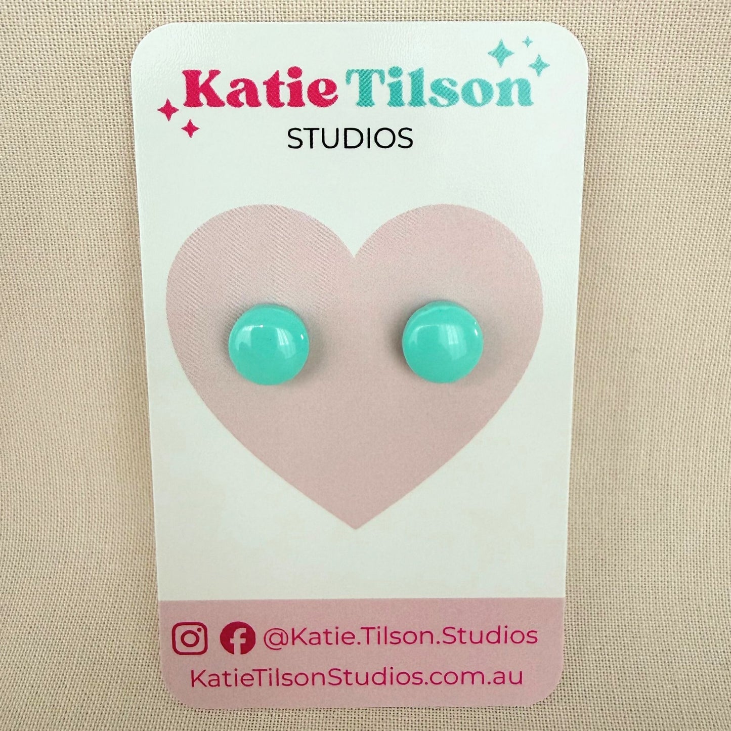 Mint colour circular stud earrings on a Katie Tilson Studios card against a beige background.