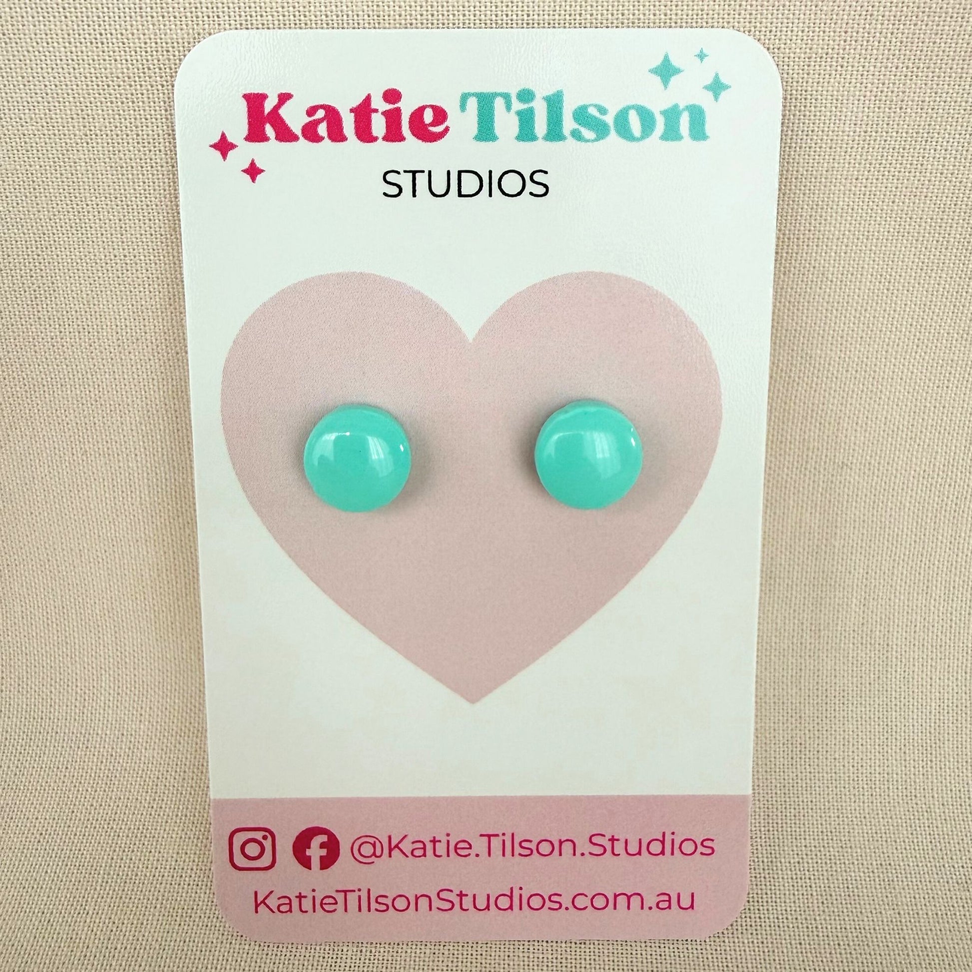 Mint colour circular stud earrings on a Katie Tilson Studios card against a beige background.