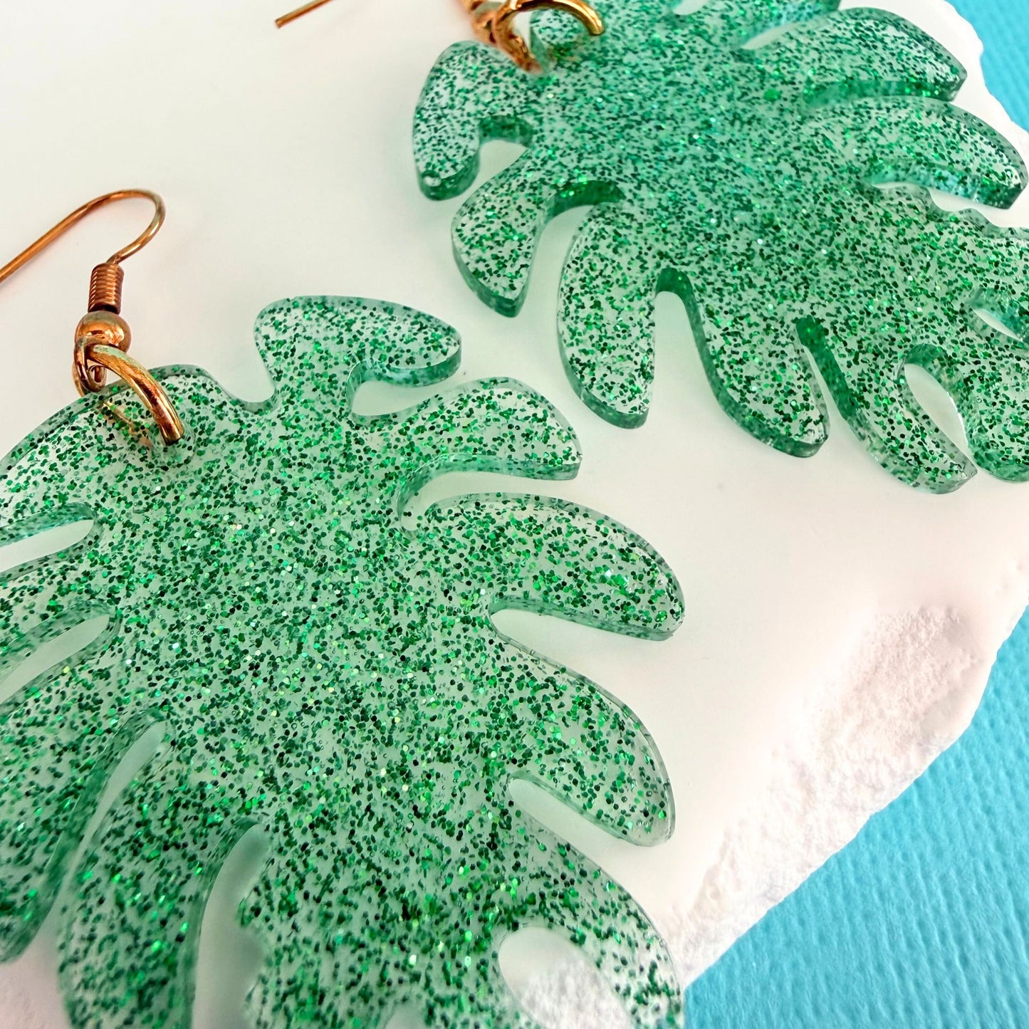 Close up of lightweight handmade dangle earrings Monstera Magic