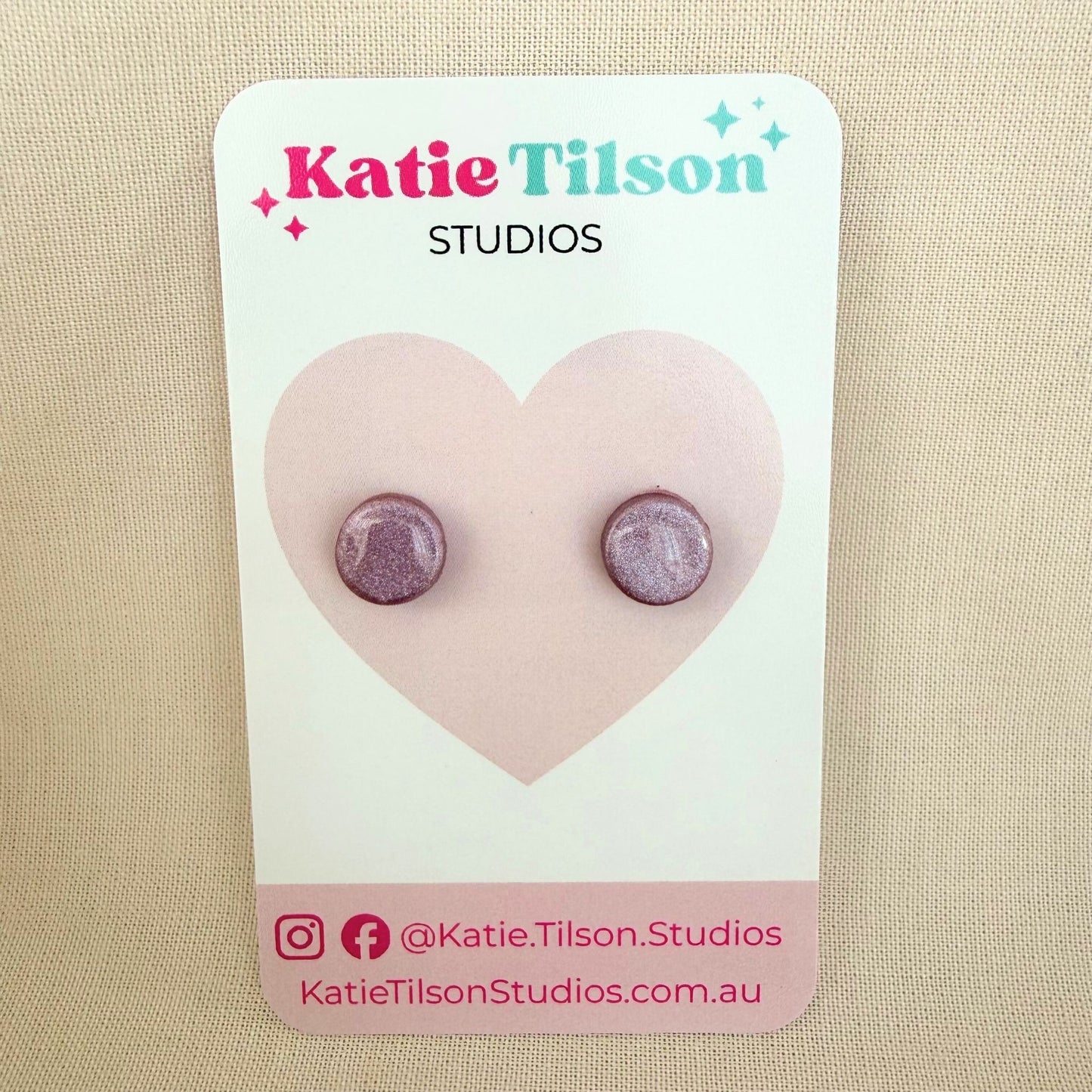 Mulberry colour circular stud earrings on a Katie Tilson Studios card against a beige background.