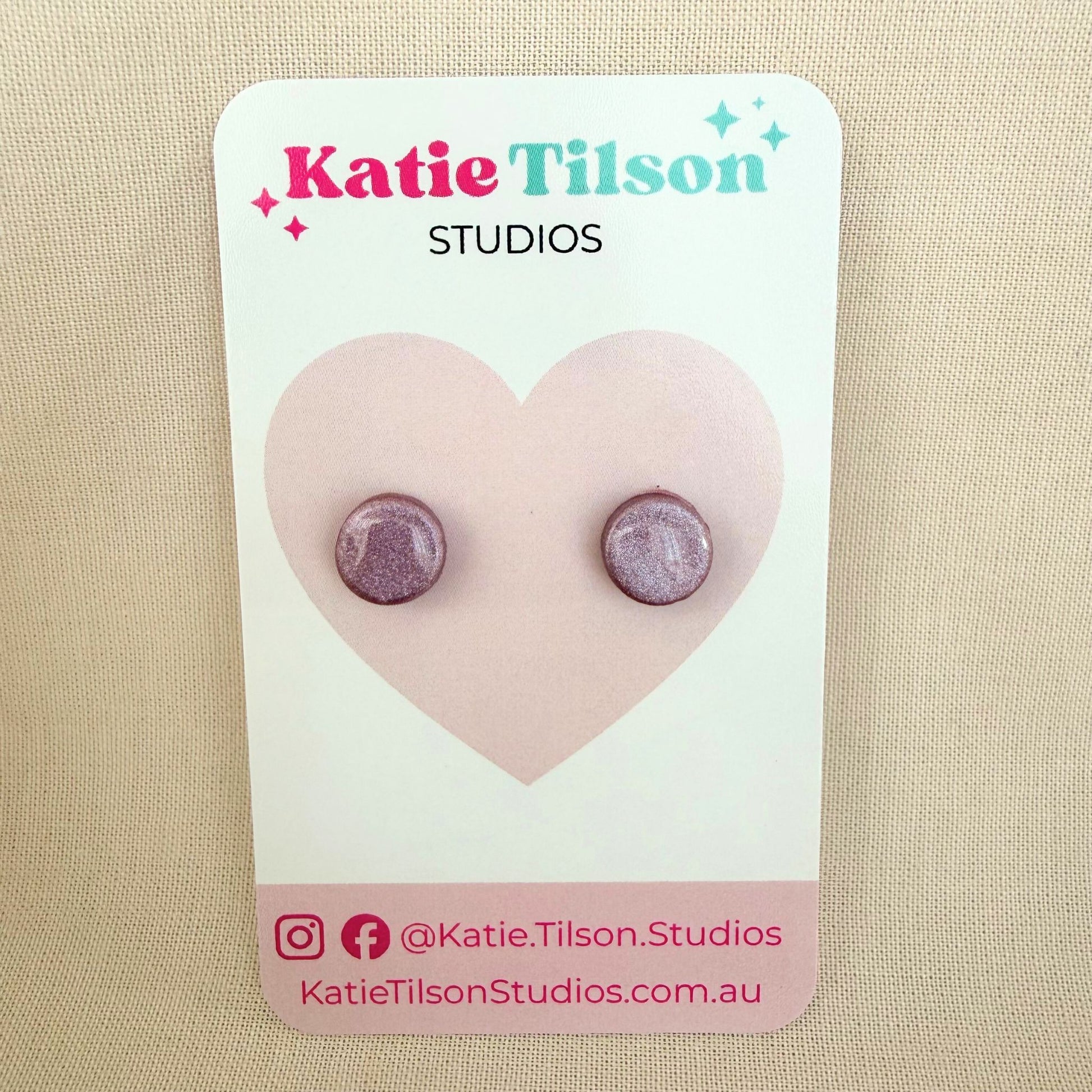 Mulberry colour circular stud earrings on a Katie Tilson Studios card against a beige background.