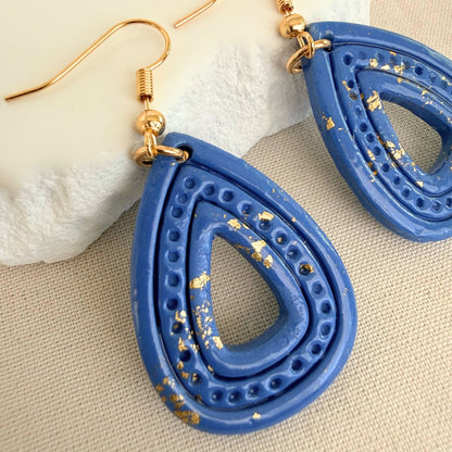 Close up of lightweight handmade dangle earrings Ocean Gleam Teardrops in blue with gold leaf details.