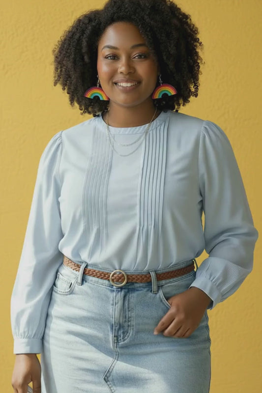 Video of woman wearing rainbow statement earrings and denim outfit turning to show movement of earrings.
