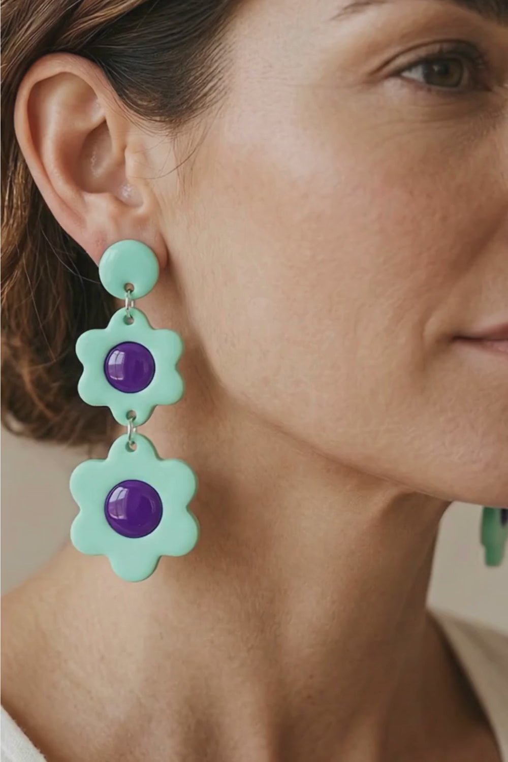 Close up video showing woman wearing mint bloom dangle earrings.