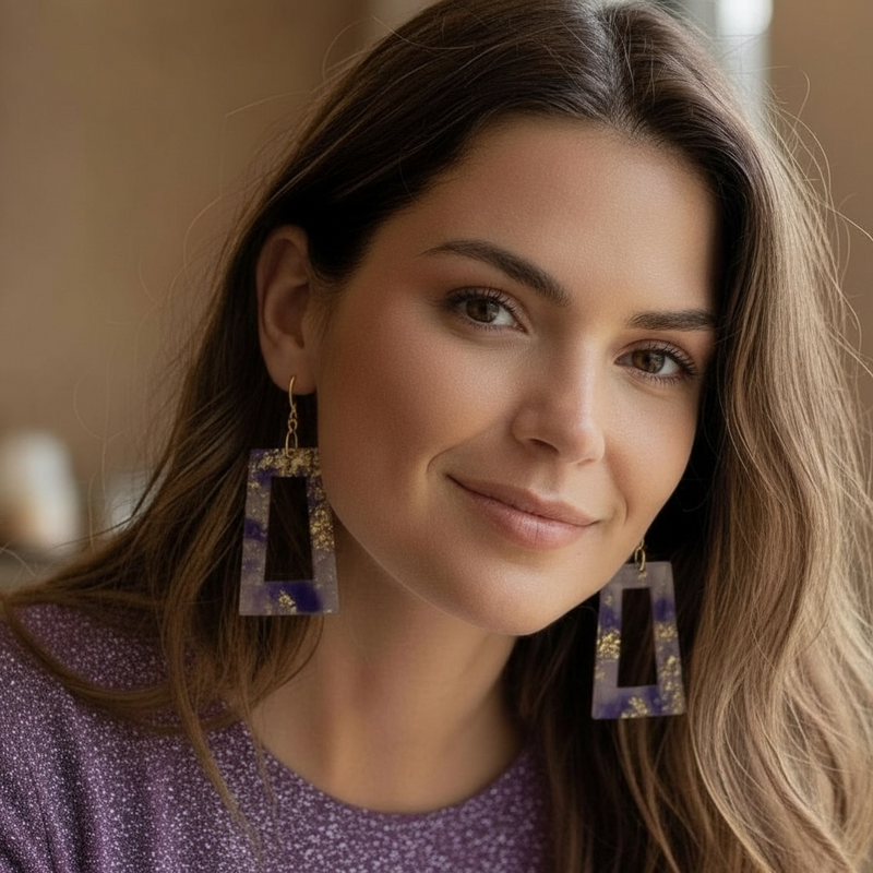 Woman wearing purple haze resin earrings with a blurred background