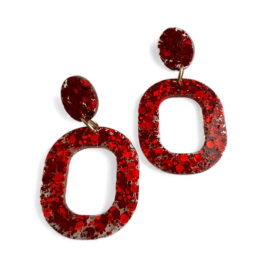 Red resin dangle earrings with bold sparkle and a glossy handmade finish.