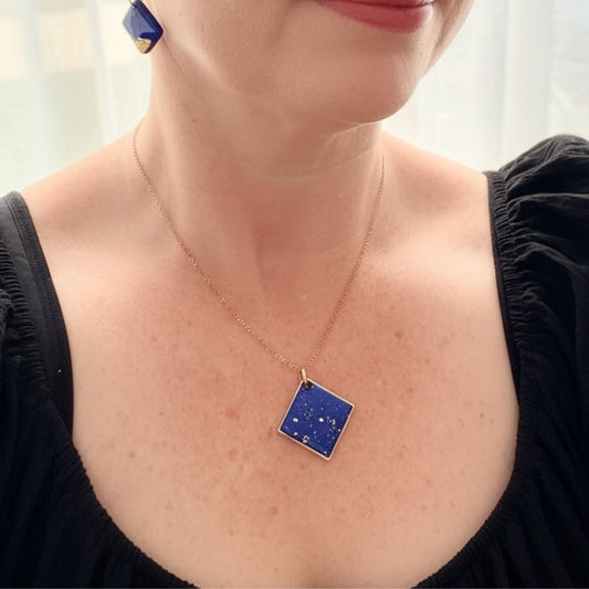 Shine On pendant necklace in cobalt blue with gold flecks and gold chain worn on woman.