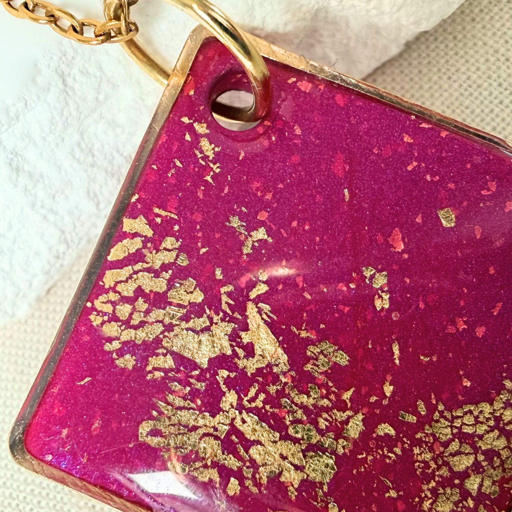 Close up of Shine On magenta coloured pendant necklace with gold flecks.
