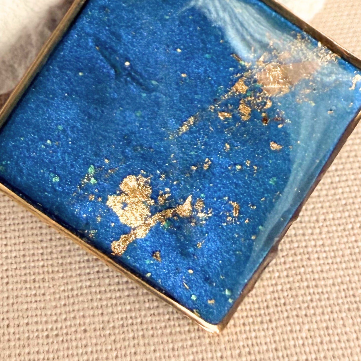 Close up of Shine On teal coloured pendant necklace with gold flecks.