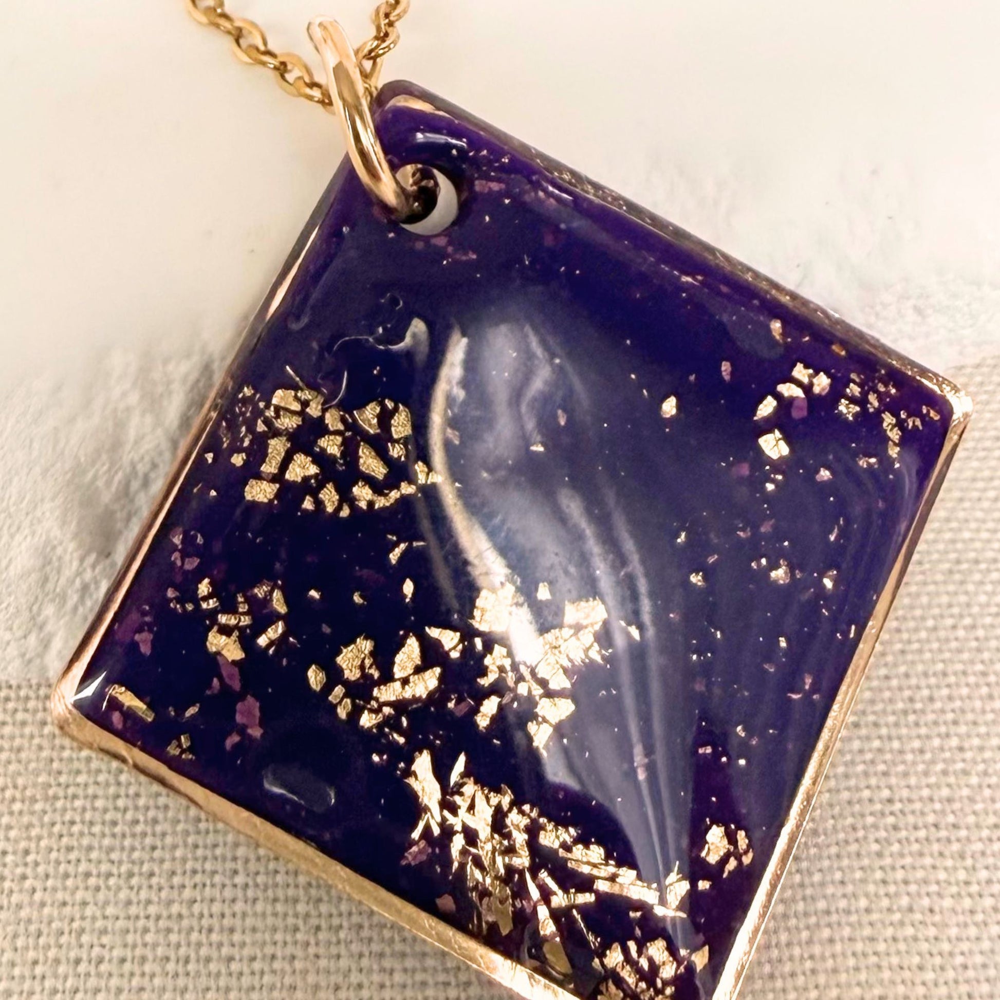 Close up of Shine On violet coloured pendant necklace with gold flecks and gold coloured chain.
