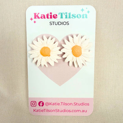 Sunny Daisy Australian handmade stud earrings on a Katie Tilson Studios branded earring card resting on a beige fabric background.