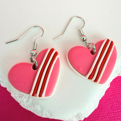 Australian handmade heart-shaped earrings with red and white stripes on a pink heart background.