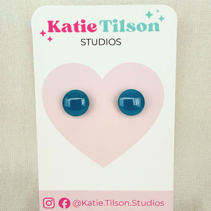 Teal circular stud earrings on a Katie Tilson Studios branded card against a beige background.