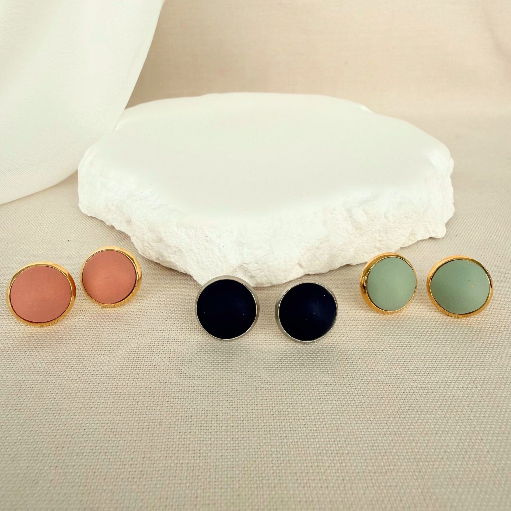 Three pairs of The Everyday Trio round stud earrings in blush, navy and eucalyptus green.