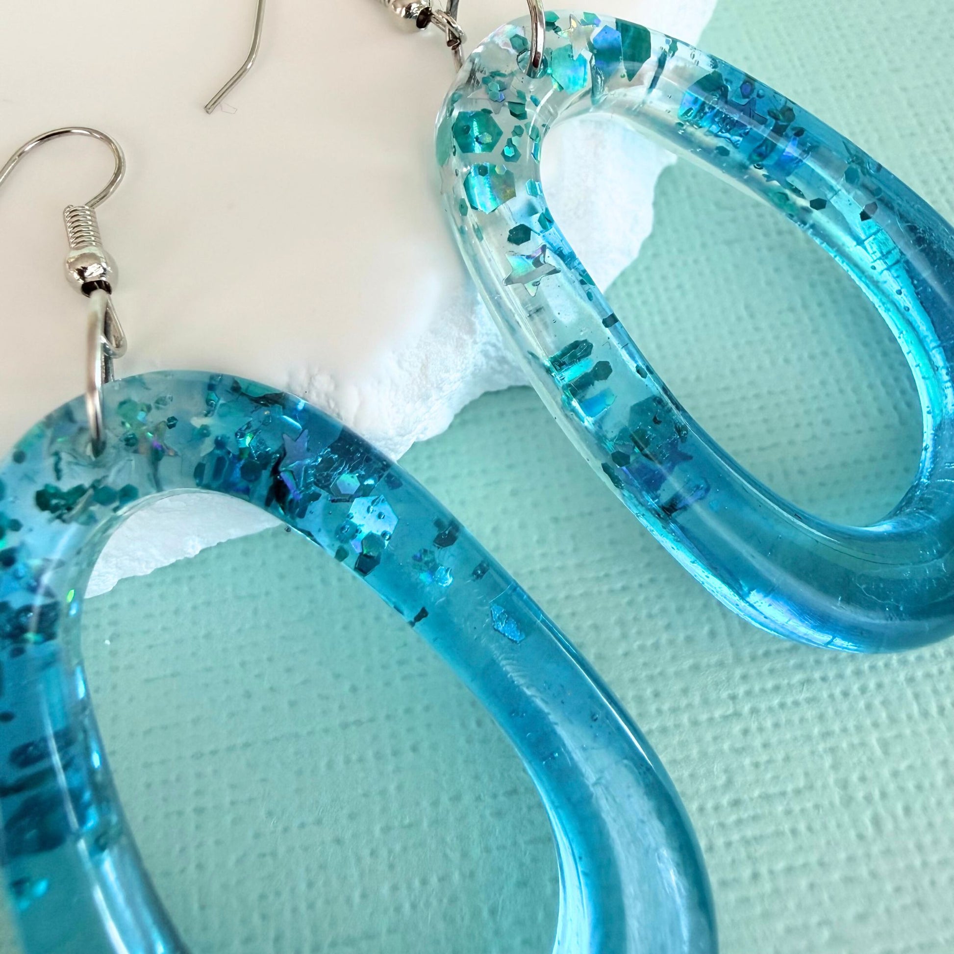 Close up of lightweight handmade dangle earrings Tidal Glow Ovals